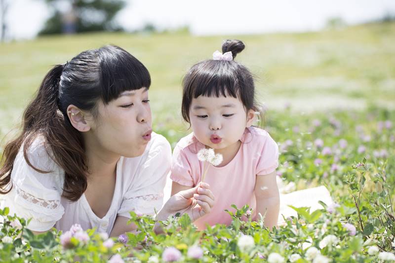 Mother and daughter playing in the spring meadow